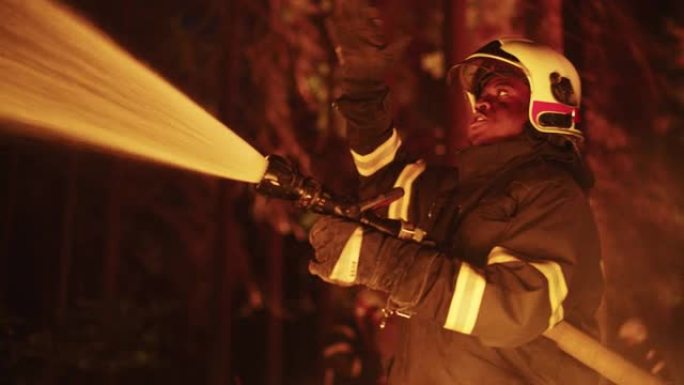 冷静并收集了非洲裔美国消防员，扑灭了森林深处的野火。专业的安全制服和头盔使用消防水带来对抗危险的野火