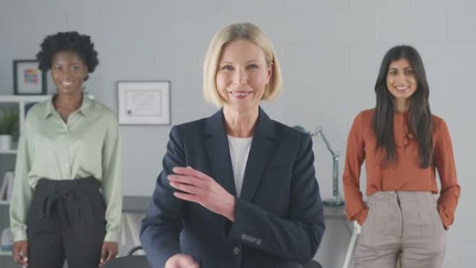 微笑的女性多种族商业团队站在办公室的肖像