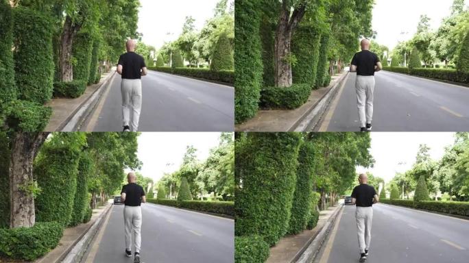 后视亚洲老年人锻炼。高级男子在公园的道路上奔跑