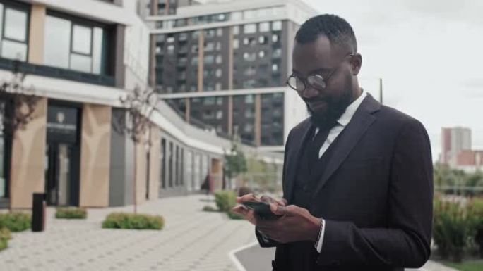 非裔美国商人在外面使用手机