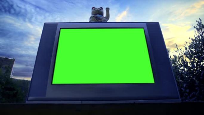 Maneki Neko猫和绿屏旧电视。低角度视图。