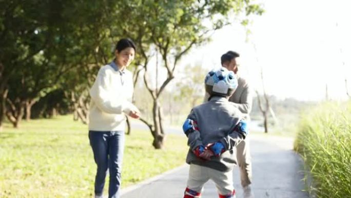 在公园学习轮滑的亚洲小男孩