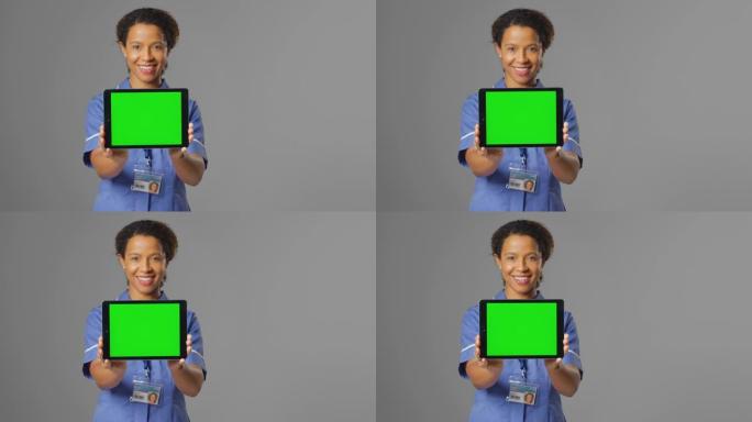 微笑护士穿着制服拿着数码平板电脑空白绿屏的肖像