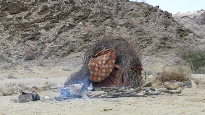 女士篝火在非洲纳米比亚简单的辛巴小屋外燃烧