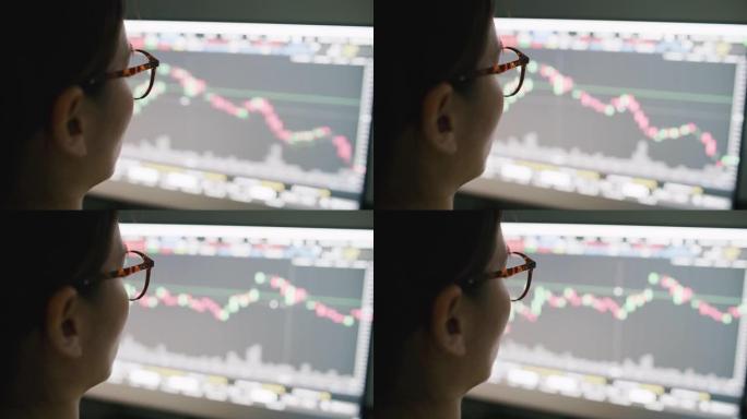 家庭办公室的女人在使用计算机时在计算机屏幕上查看股票市场数据