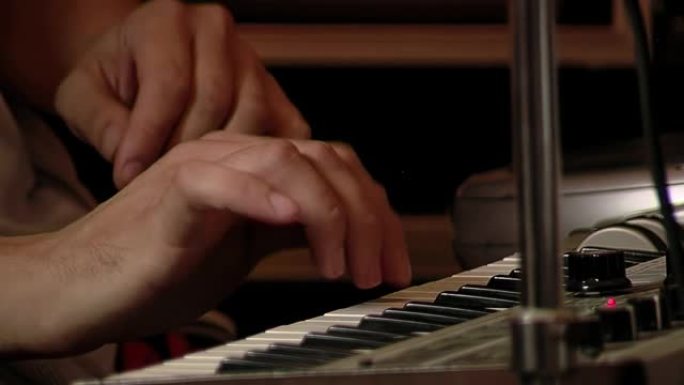 演奏电钢琴或电子键盘的音乐家。特写。