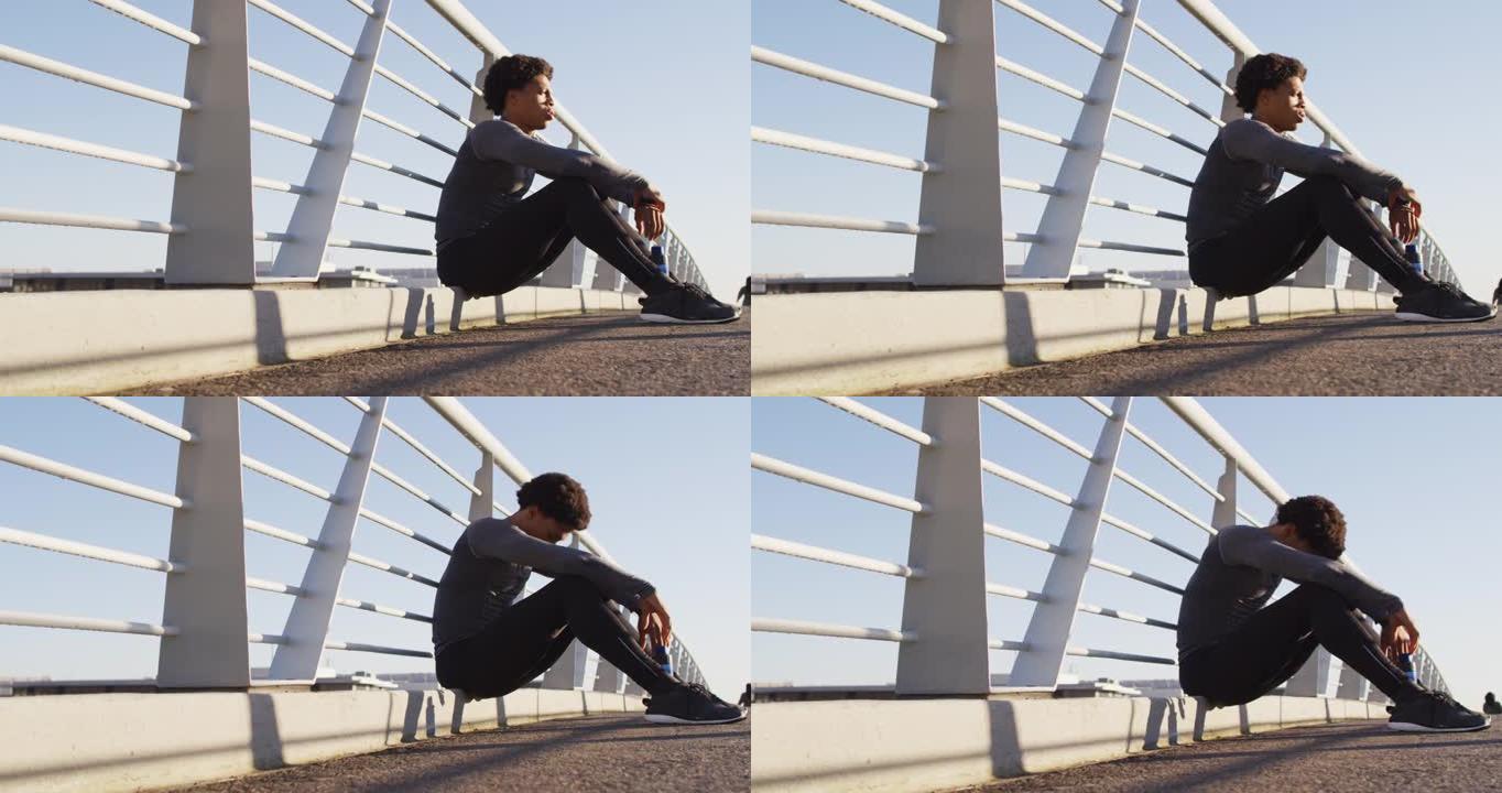 适合非裔美国人在城市户外锻炼，坐在人行天桥上休息
