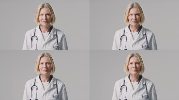 工作室肖像成熟的女医生与听诊器穿着白色外套在素色背景下