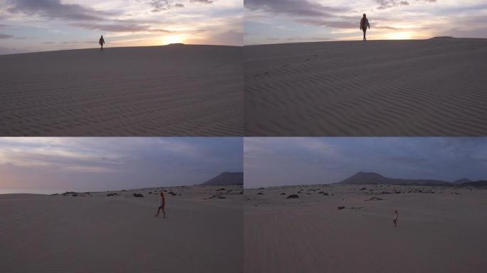 空中: 女性在日出时穿越沙漠