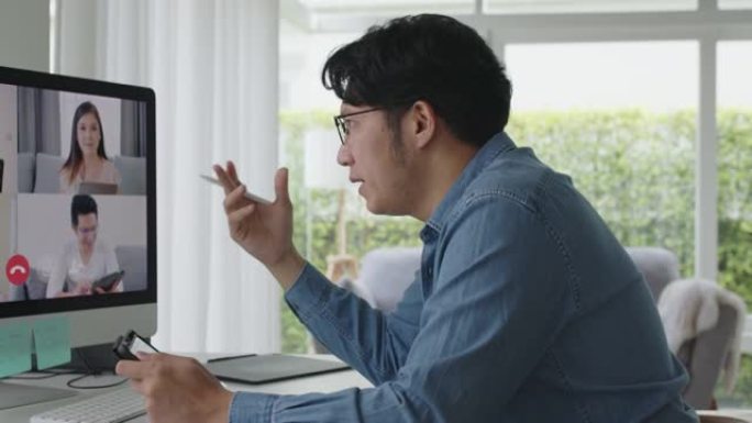 亚洲男子在视频通话中使用计算机和平板电脑在线会议