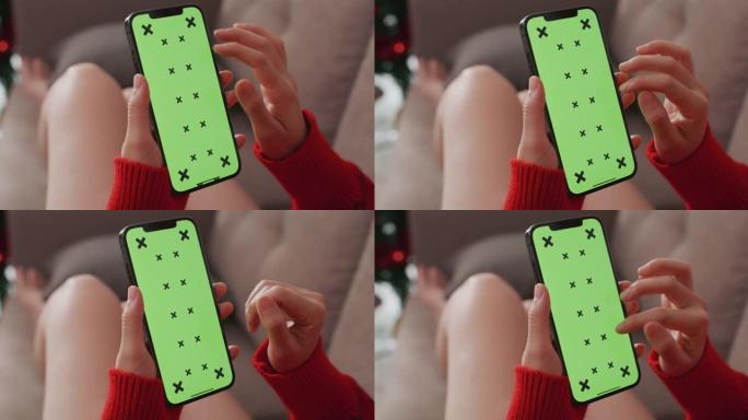 女人在圣诞节使用绿屏智能手机