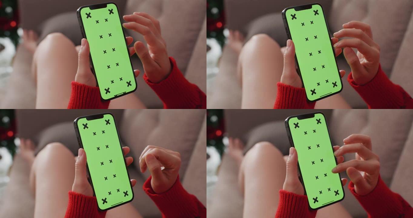 女人在圣诞节使用绿屏智能手机