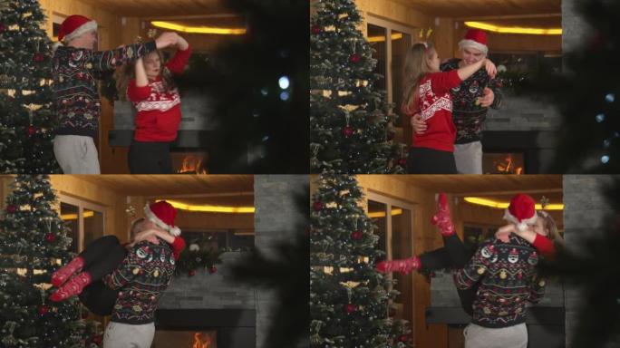 年轻人在圣诞树旁一起跳舞时抬起女友