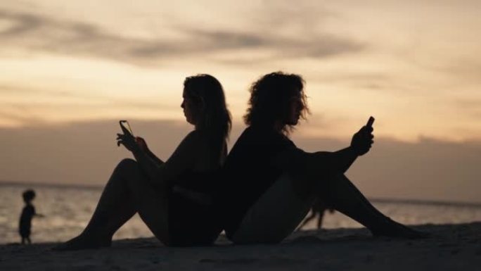 在海滩上使用电话的朋友