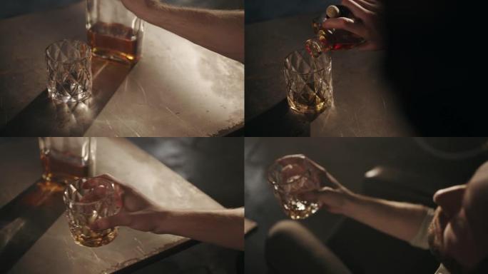 一个男人在空杯子里倒些威士忌，然后从中A一口的高角度视图