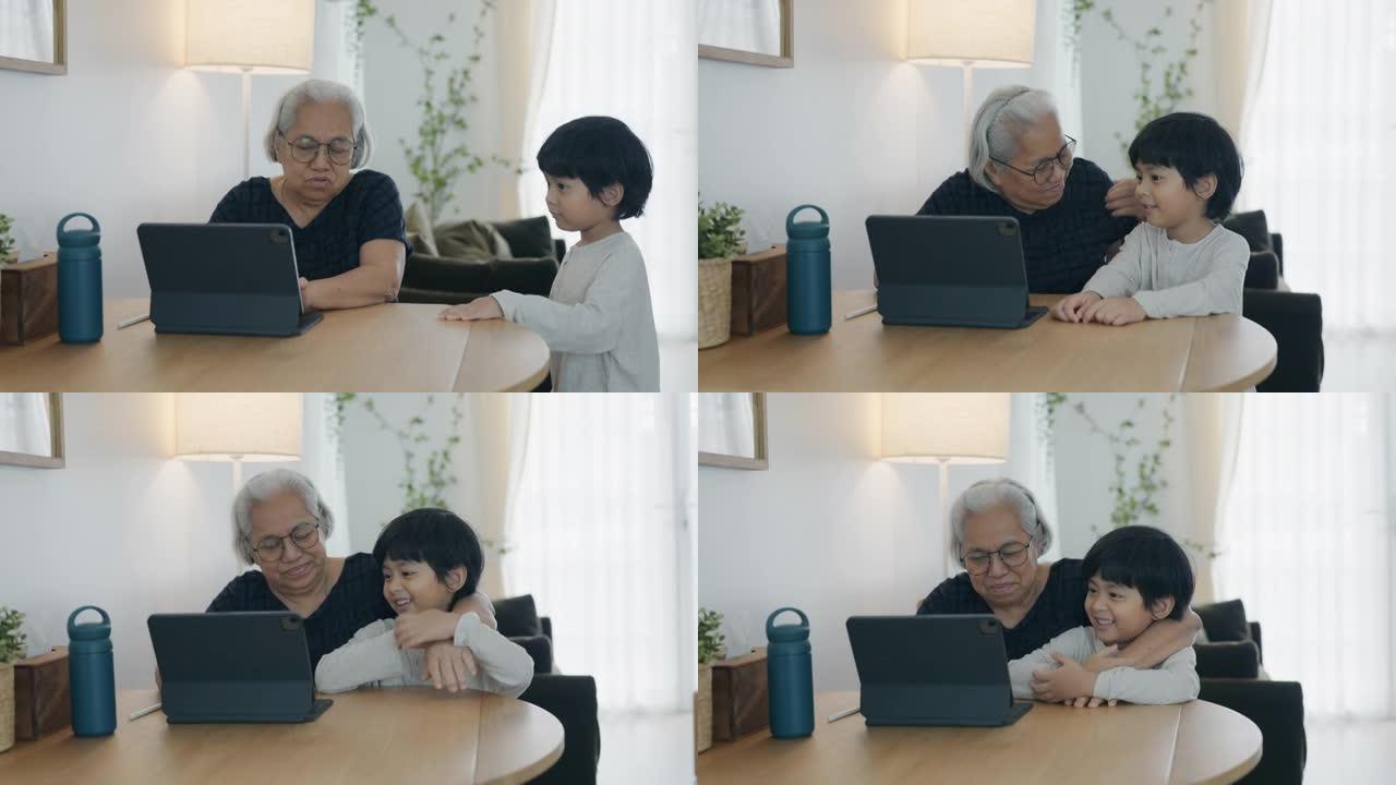 孙子和祖母使用笔记本电脑。