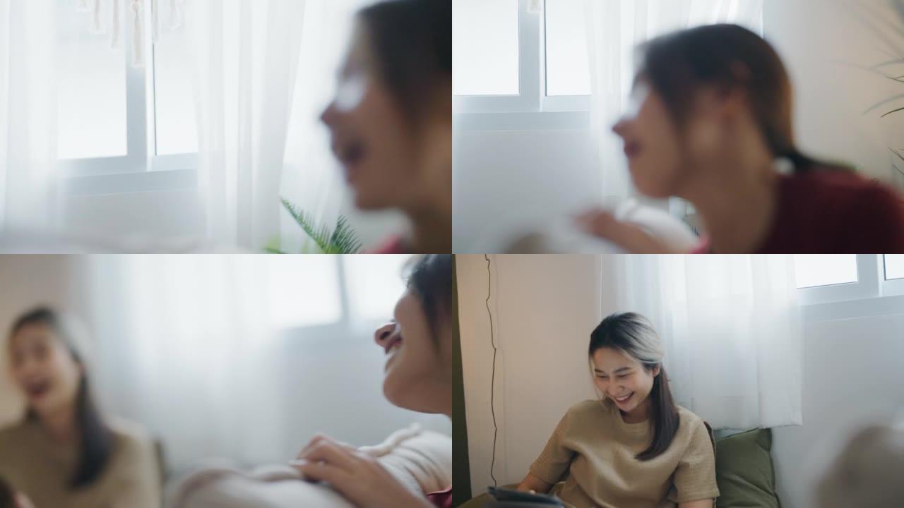 年轻的亚洲妇女在床上使用平板电脑