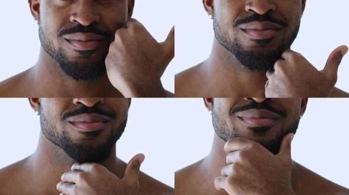 年轻的非洲裔美国男子触摸修剪过的胡须。