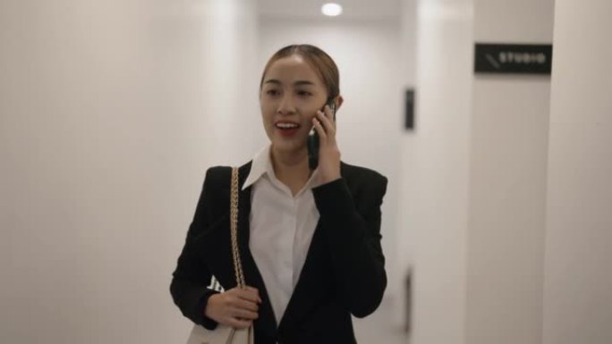 自信年轻的亚洲女商人工人边走边打电话。