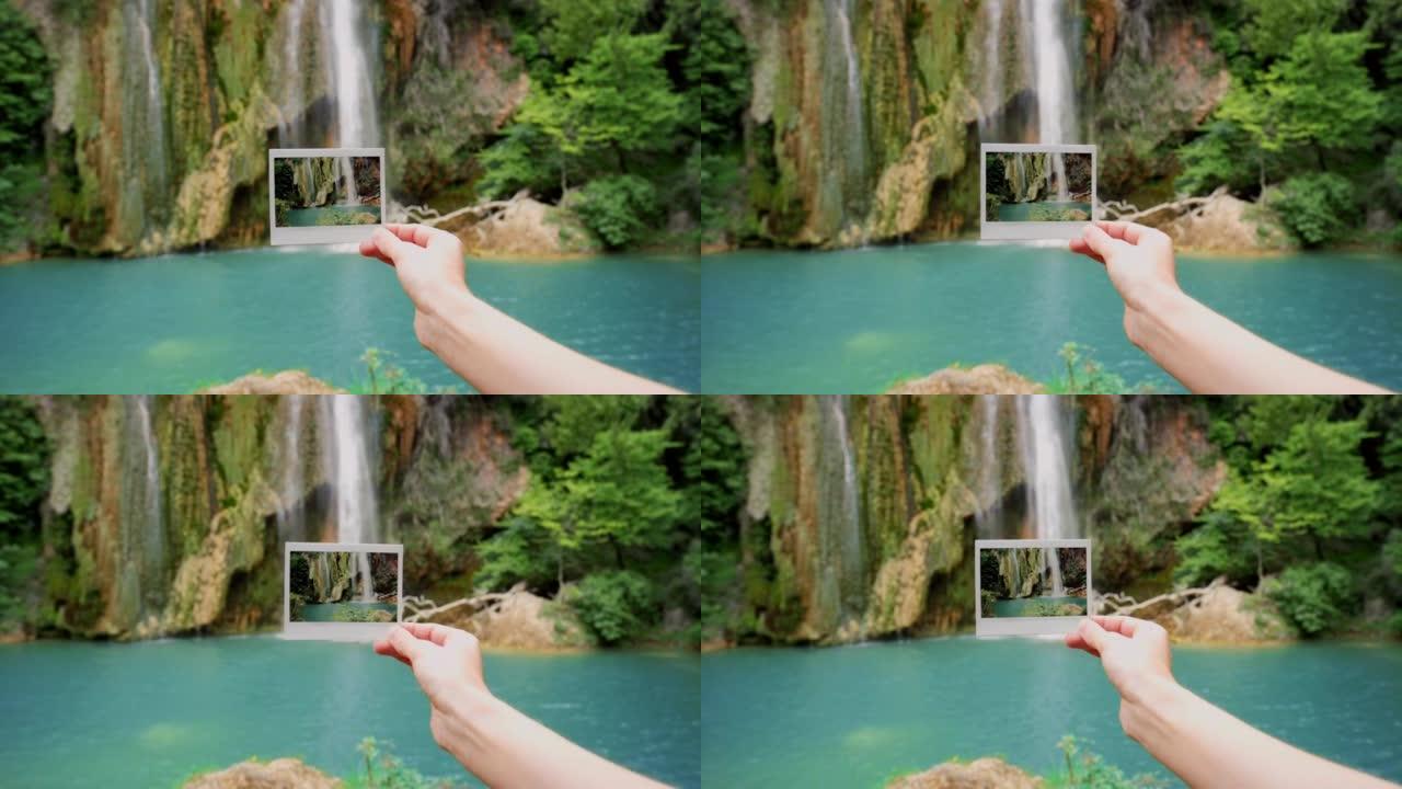 一个无法辨认的女人在瀑布前拿着宝丽来的4k录像