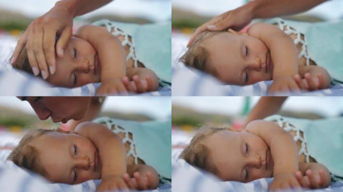 neo mother的真实特写镜头是在海滩上的掩护下睡觉时爱抚和亲吻新生婴儿