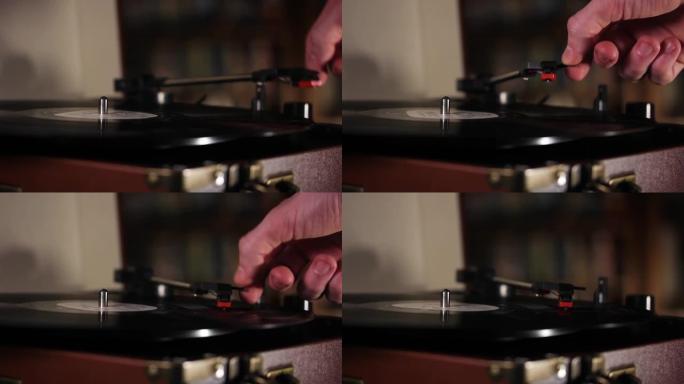 用手将电唱机的针放在旋转的黑胶唱片上。