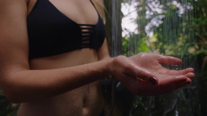女人在淋浴抓水在户外洗澡在大自然穿着比基尼认不出来的人