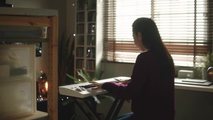 千禧一代女性在家学习弹奏键盘钢琴