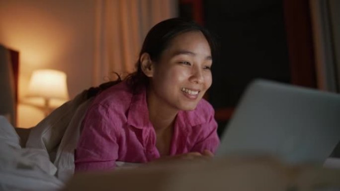 女人在深夜使用笔记本电脑。她正在上网或从事新项目。