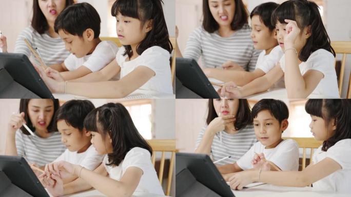快乐亚洲家庭在家上学，妈妈在家教孩子们在客厅使用数字平板电脑。