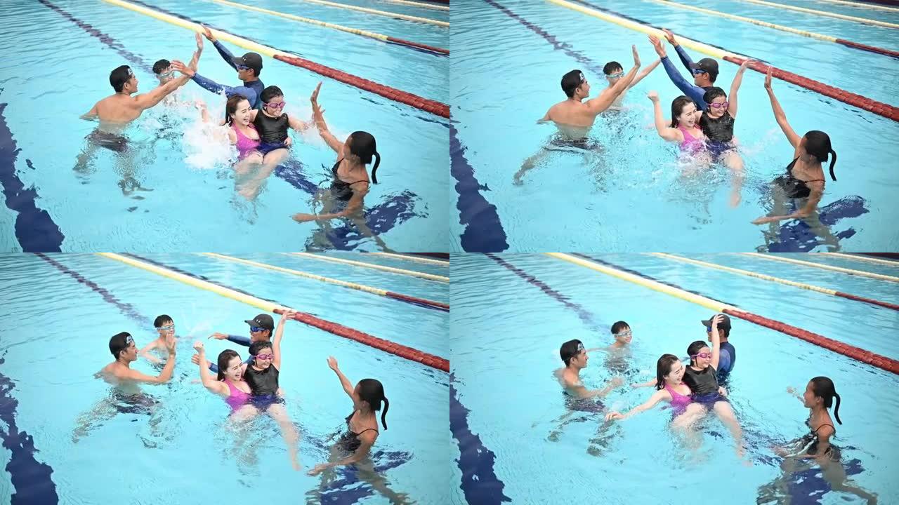 亚洲华人教练在游泳池训练年轻家庭