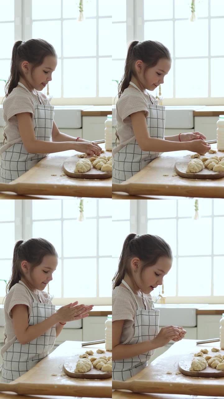 小女孩在家里的厨房里穿围裙烹饪糕点