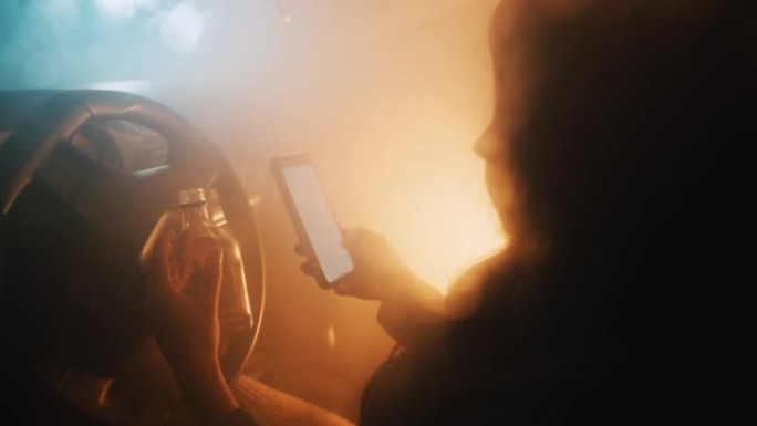 年轻女子用手机拿着酒精坐在车里
