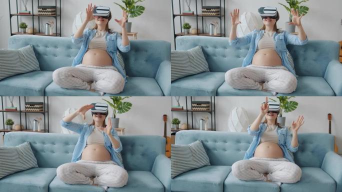 孕妇的慢动作使用虚拟现实眼镜在家里移动手和微笑