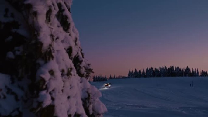 黄昏时在滑雪坡上的SLO MO雪犁卡车