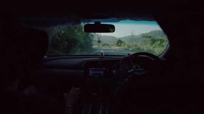 旅游男子在旅行途中开车穿过森林。
