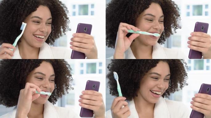 4k视频片段，一名年轻女子在家里的浴室里刷牙时在手机上