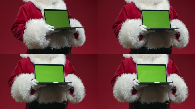 一个没有头的圣诞老人的旋转形象，手里拿着一个带色度键的笔记本电脑，在红色背景上