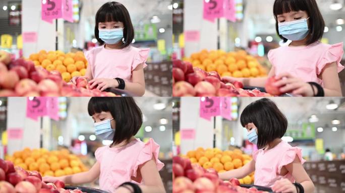 一个亚洲的中国女孩在超市买水果在周末看水蜜桃