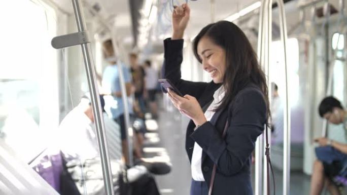 亚洲女商人在火车上使用智能手机