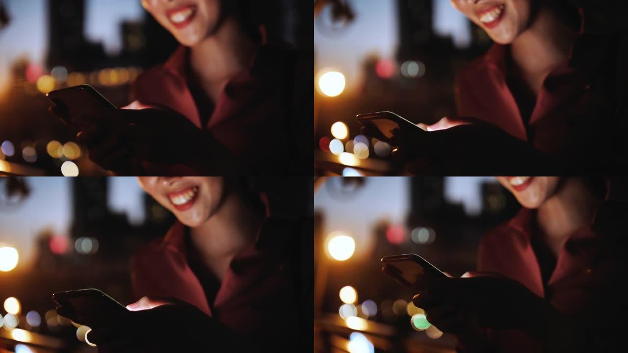 在夜城的街道上散步时，使用手机的迷人女人的特写镜头