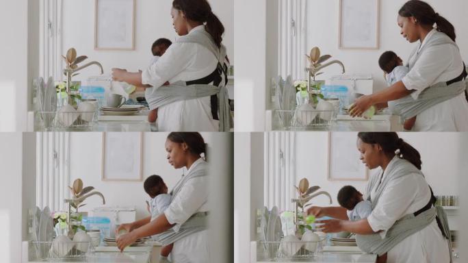 非裔美国母亲抱着在家工作的婴儿洗碗清洁厨房照顾幼儿做家务享受母亲