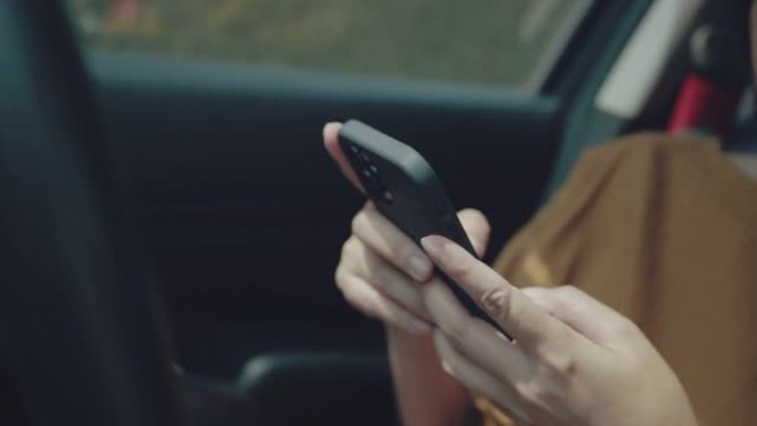 年轻女子乘坐智能手机上带有导航仪的汽车