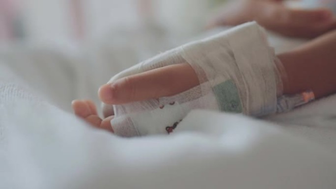 儿童的手在医院的病床上