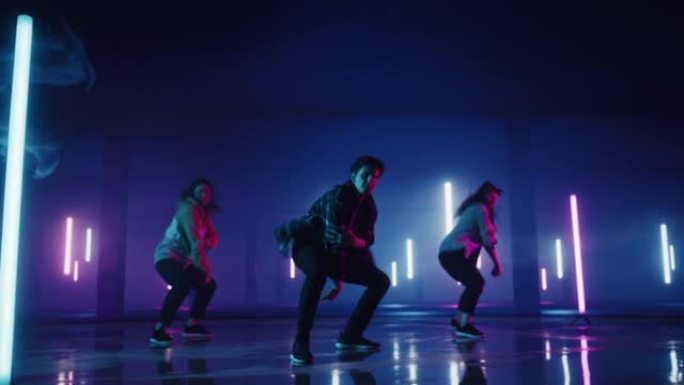 由三个不同的时尚专业舞者组成的小组，在虚拟制作工作室环境中表演嘻哈舞蹈套路，配有霓虹灯的3D地下车库