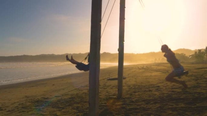 移动镜头: 年轻夫妇在日落时在热带海滩上摇摆