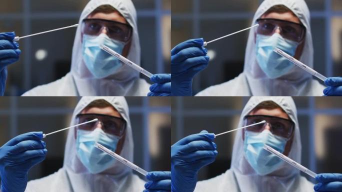 白种人男性医务人员戴着防护服口罩和手套在实验室检查dna拭子