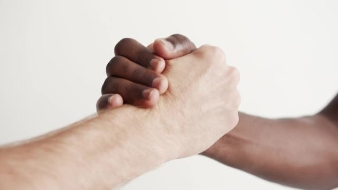 两个多民族朋友的特写强烈握手。合作和跨种族友谊的概念。多元文化和国际社会。跨国千禧一代给予Arm 4