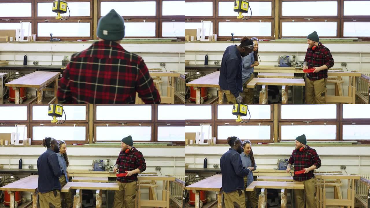 木匠在木工车间向同事解释如何油漆木材