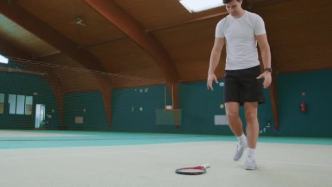 失望的年轻网球运动员将球拍扔在地上